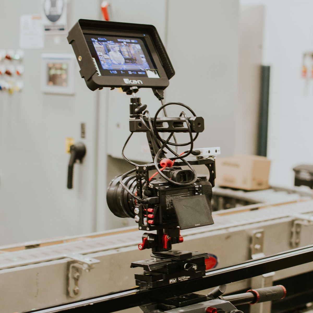 Professional cinema camera rig with an on-board monitor mounted on a slider during a video production shoot