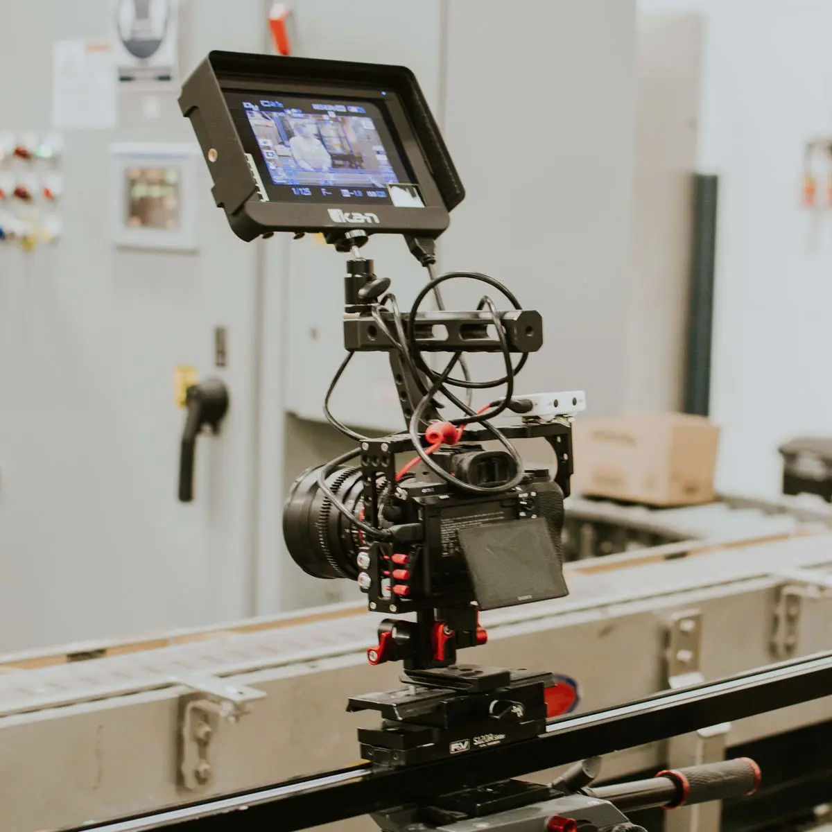 Professional cinema camera rig with an on-board monitor mounted on a slider during a video production shoot